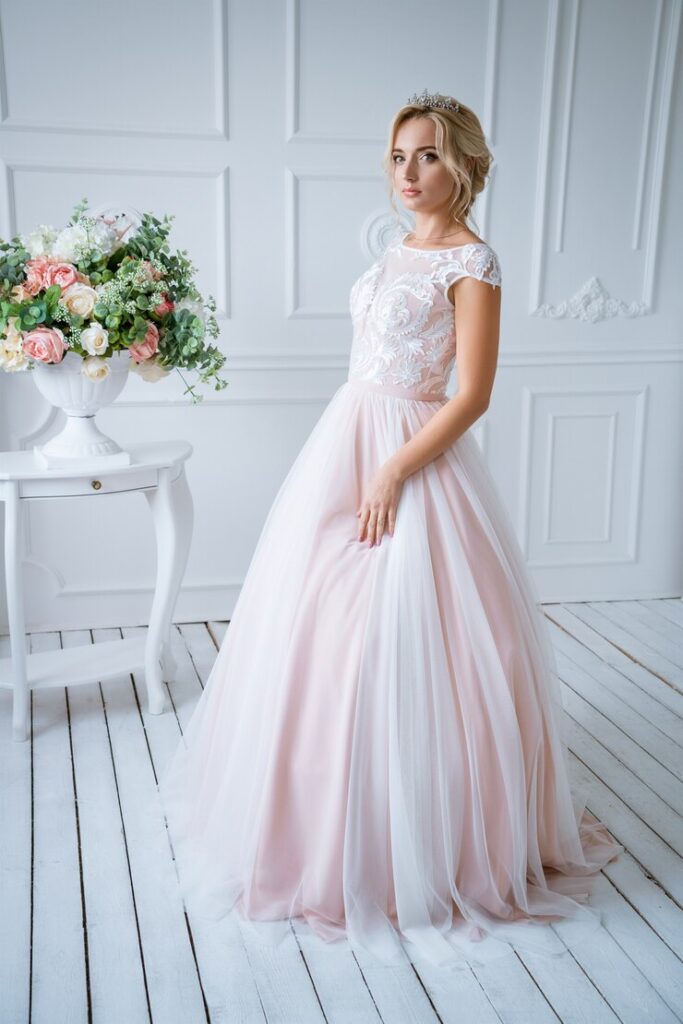 uma-linda-noiva-com-cabelo-e-maquiagem-esta-em-um-delicado-vestido-de-noiva-rosa-em-uma-decoracao-leve-com-flores_78492-3932